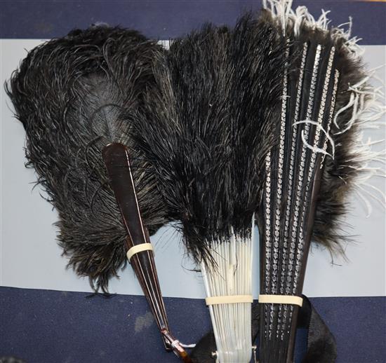 A black and white ostrich feather fan and two black ostrich feather fans,